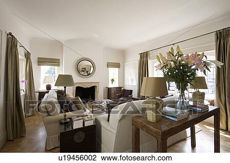 Antique table behind cream sofa in cream country living room View Large Photo Image Stock Image - Antique table behind cream sofa in cream country living room. Fotosearch