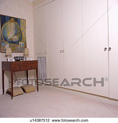 Antique table beside large fitted wardrobe in townhouse bedroom View Large Photo Image Stock Image - Antique table beside large fitted wardrobe in townhouse bedroom. Fotosearch