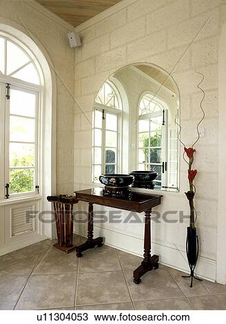 Arched mirror above console table in hall with stone walls View Large Photo Image Stock Image - Arched mirror above console table in hall with stone walls. Fotosearch