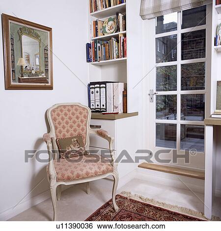 Armchair in front of shelving beside glazed door in corner of apartment living room View Large Photo Image Stock Photograph - Armchair in front of shelving beside glazed door in corner of apartment living room. Fotosearch