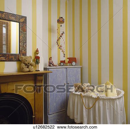 Baby's cot with white muslin trim in nursery bedroom with yellow striped wallpaper View Large Photo Image Stock Image - Baby's cot with white muslin trim in nursery bedroom with yellow striped wallpaper . Fotosearch