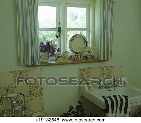 Stock Photo - Basin below window in small cottage bathroom. Fotosearch