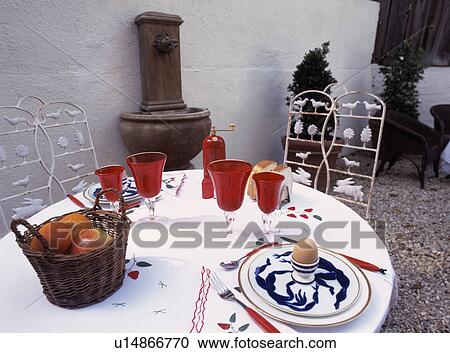 Basket of apples with red glasses on table set for breakfast on courtyard patio View Large Photo Image Stock Image - Basket of apples with red glasses on table set for breakfast on courtyard patio. Fotosearch