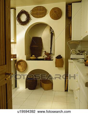 Stock Image - Baskets above alcove in traditional kitchen. Fotosearch