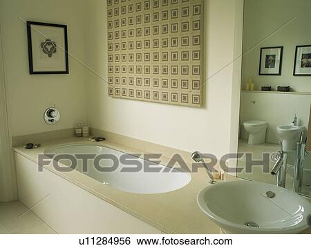 Stock Photograph - Bath and basin in modern neutral bathroom. Fotosearch