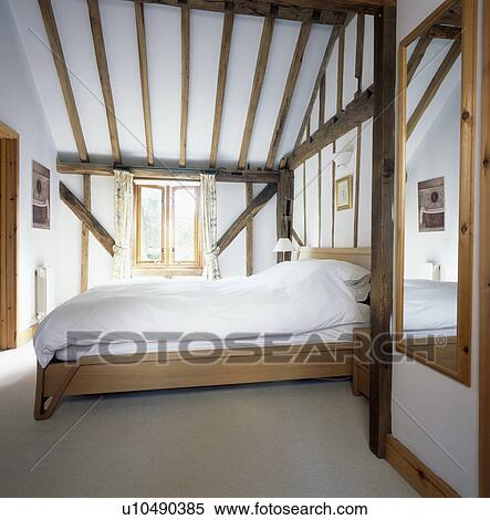 Beamed country bedroom with white bedline on pine bed View Large Photo Image Stock Photography - Beamed country bedroom with white bedline on pine bed. Fotosearch