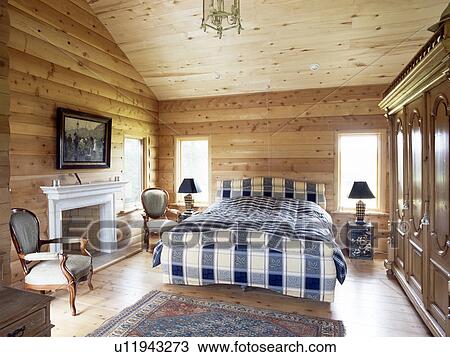 Bed with blue+white bedlinen in pine panelled country bedroom View Large Photo Image Stock Image - Bed with blue+white bedlinen in pine panelled country bedroom. Fotosearch