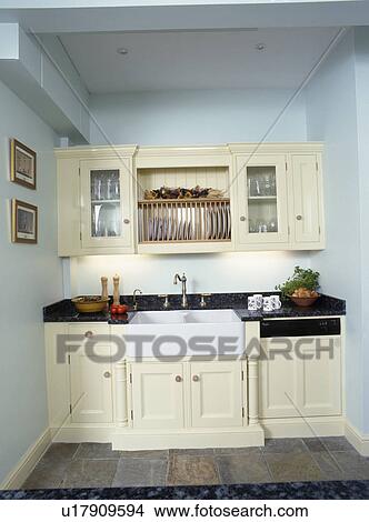Picture - Belfast sink in cream fitted unit in pastel blue traditional kitchen. Fotosearch