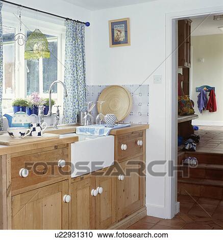 Belfast sink in fitted wood unit below window in cottage kitchen View Large Photo Image Stock Image - Belfast sink in fitted wood unit below window in cottage kitchen. Fotosearch