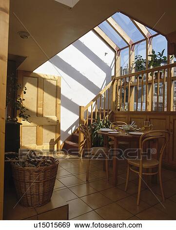 Bentwood chairs and small wooden table in dining room extension with glass ceiling above mezzanine floor View Large Photo Image Stock Photo - Bentwood chairs and small wooden table in dining room extension with glass ceiling above mezzanine floor. Fotosearch