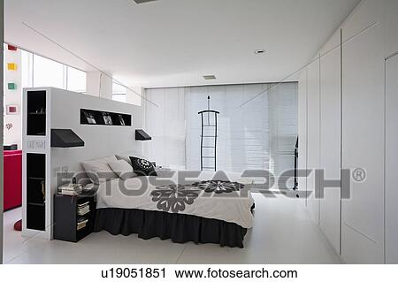 Black And White Bedlinen On Bed In Large Modern White Bedroom With