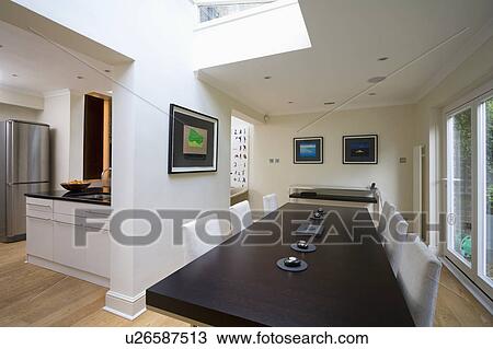 Stock Image - Black B+B Italia rectangular table in modern dining room extension. Fotosearch