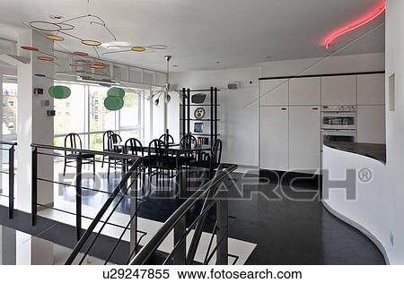 Stock Photography - Black flooring in modern open-plan loft conversion kitchen dining room. Fotosearch