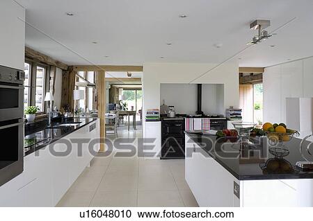 Black Granite Worktop On Island Unit In Modern White Barn Conversion Kitchen With Limestone Flooring Black Granite Worktop On Island Unit In Modern White Barn Conversion Kitchen With Limestone Flooring