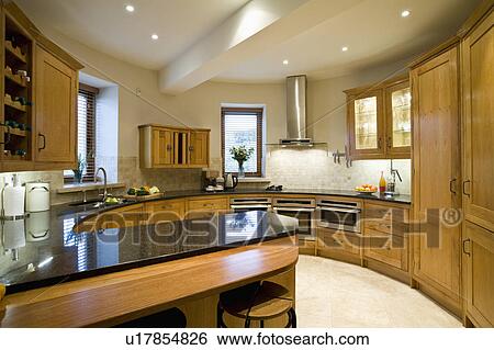 Black granite worktop on peninsular unit in oast house kitchen with oak cupboards and downlighting View Large Photo Image Stock Photograph - Black granite worktop on peninsular unit in oast house kitchen with oak cupboards and downlighting. Fotosearch