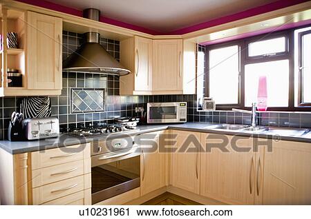 Black wall tiles above hob and oven in modern beech kitchen with grey worktops View Large Photo Image Stock Image - Black wall tiles above hob and oven in modern beech kitchen with grey worktops. Fotosearch