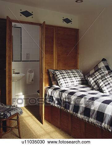 Black+white bedlinen on built-in bed in compact bedroom with ensuite bathroom View Large Photo Image Stock Image - Black+white bedlinen on built-in bed in compact bedroom with ensuite bathroom. Fotosearch