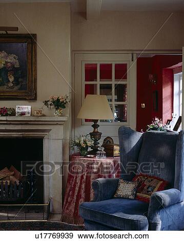 Blue armchair beside fireplace in traditional living room View Large Photo Image Stock Photo - Blue armchair beside fireplace in traditional living room. Fotosearch