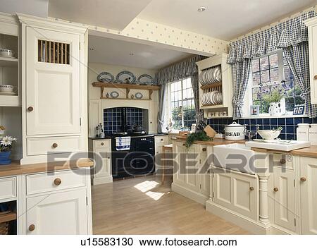 Blue checked curtains on window in country kitchen with fitted cream units View Large Photo Image Stock Image - Blue checked curtains on window in country kitchen with fitted cream units. Fotosearch