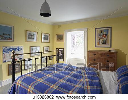 Blue checked duvet on iron bed in yellow bedroom View Large Photo Image Stock Image - Blue checked duvet on iron bed in yellow bedroom. Fotosearch