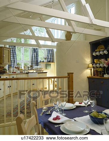 Blue cloth on table in kitchen dining room extension with white beams on apex ceiling View Large Photo Image Stock Image - Blue cloth on table in kitchen dining room extension with white beams on apex ceiling. Fotosearch