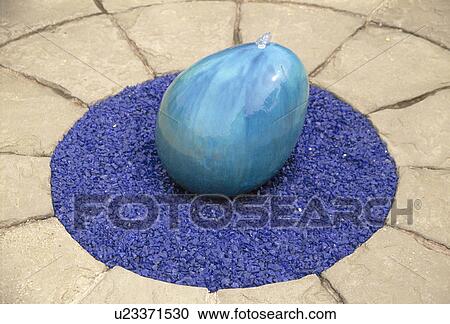 Blue egg-shaped water feature on patio. View Large Photo Image Stock Image - Blue egg-shaped water feature on patio.. Fotosearch