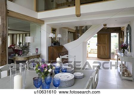 Blue glasses on table in open-plan dining room in country barn conversion View Large Photo Image Stock Image - Blue glasses on table in open-plan dining room in country barn conversion. Fotosearch