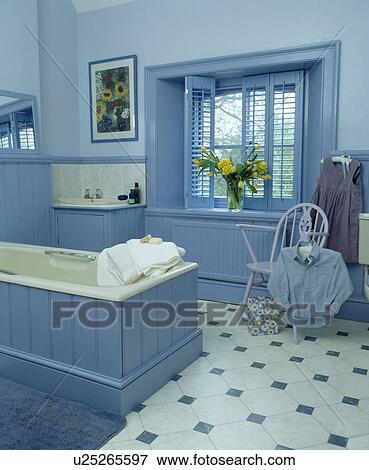 Blue plantation shutters in blue bathroom with tonque+groove panelled bath View Large Photo Image Stock Photo - Blue plantation shutters in blue bathroom with tonque+groove panelled bath. Fotosearch