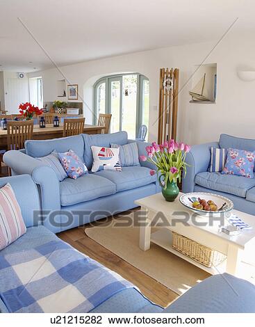 Blue sofas and cream wooden coffee-table in white coastal living room and dining room View Large Photo Image Stock Image - Blue sofas and cream wooden coffee-table in white coastal living room and dining room. Fotosearch