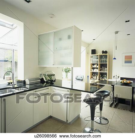 Bomba stools at granite-toppedm peninsular breakfast bar in large modern open-plan kitchen and dining room View Large Photo Image Stock Photograph - Bomba stools at granite-toppedm peninsular breakfast bar in large modern open-plan kitchen and dining room. Fotosearch
