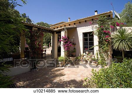 Bougainvillea on house in Mallorca with paved patio and covered veranda View Large Photo Image Stock Photography - Bougainvillea on house in Mallorca with paved patio and covered veranda. Fotosearch