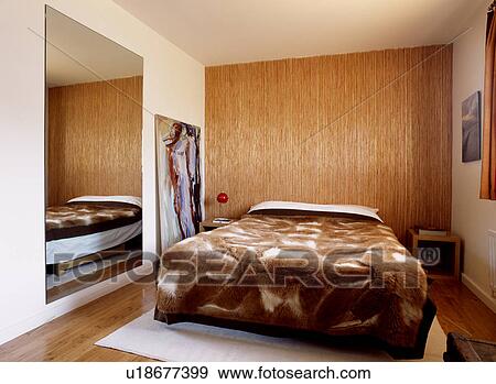Brown straw and cotton wall covering in modern apartment bedroom with faux fur throw on the bed View Large Photo Image Stock Photo - Brown straw and cotton wall covering in modern apartment bedroom with faux fur throw on the bed. Fotosearch