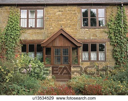 Brown wooden-framed windows and porch on stone country cottage View Large Photo Image Stock Photo - Brown wooden-framed windows and porch on stone country cottage. Fotosearch