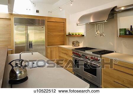 Stock Photo Of Chrome Kettle On Island Unit In Modern Kitchen With Chrome Kettle On Island Unit In Modern Kitchen With Stainless Steel Range Oven