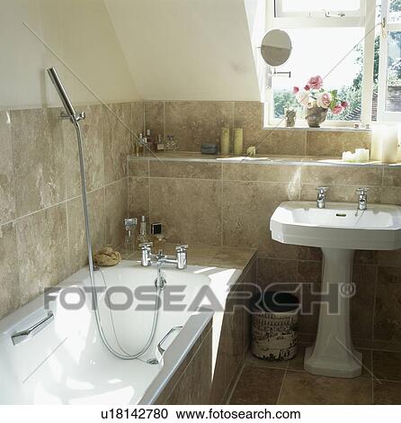 Chrome shower in bath in white bathroom with beige tiled walls and white pedestal basin View Large Photo Image Stock Image - Chrome shower in bath in white bathroom with beige tiled walls and white pedestal basin. Fotosearch