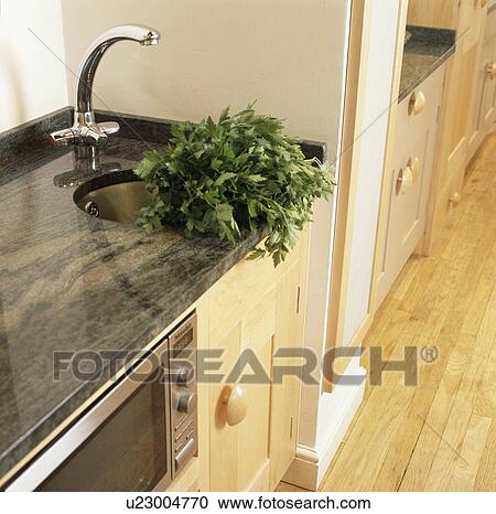 Chrome tap and small circular underset sink in granite worktop on fitted kitchen unit with microwave oven View Large Photo Image Stock Image - Chrome tap and small circular underset sink in granite worktop on fitted kitchen unit with microwave oven. Fotosearch