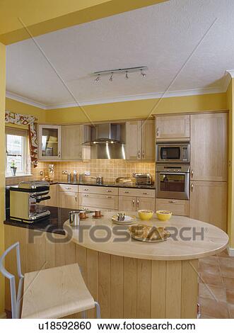 Circular breakfast bar on fitted unit in modern yellow kitchen View Large Photo Image Stock Image - Circular breakfast bar on fitted unit in modern yellow kitchen. Fotosearch