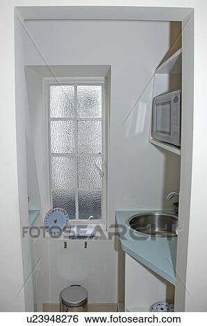 Circular stainless-steel sink in pale blue worktop in small modern galley kitchen with frosted glass window View Large Photo Image Stock Photograph - Circular stainless-steel sink in pale blue worktop in small modern galley kitchen with frosted glass window. Fotosearch