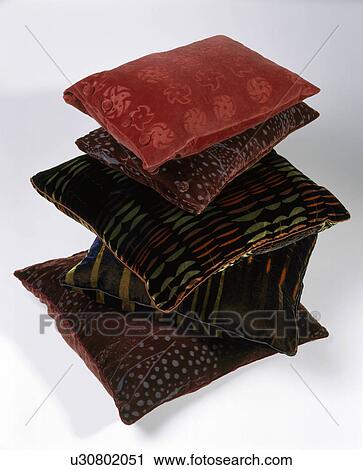 Stock Image - Close-up of a pile of velvet cushions. Fotosearch