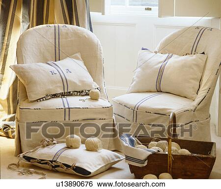Stock Photograph - Close-up of armchairs with loose-covers and cushions made from linen tea-towels. Fotosearch