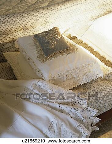 Stock Image - Close-up of beaded Victorian cushion and lace-trimmed cushion and linen on chaise-longue. Fotosearch