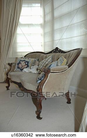 Close-up of beige velour antique sofa in front of window with closed white linen blinds View Large Photo Image Stock Image - Close-up of beige velour antique sofa in front of window with closed white linen blinds . Fotosearch