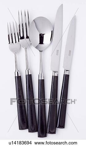 Picture - Close-up of black-handled stainless-steel Gucci cutlery. Fotosearch