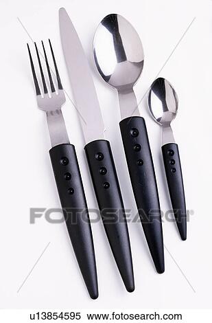 Stock Photography - Close-up of black-handled stainless steel knife and fork with spoons. Fotosearch