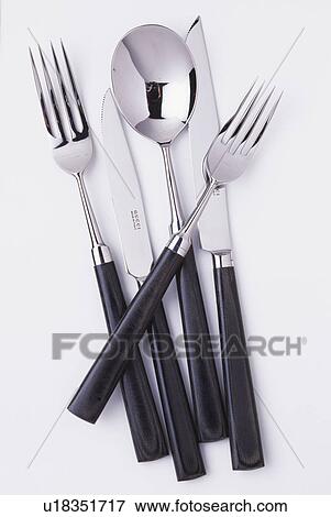 Stock Photo - Close-up of black-handled stainless-steel knives and forks with spoon. Fotosearch