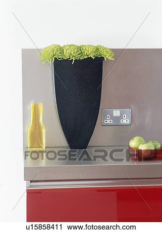 Close-up of black vase with green flowers View Large Photo Image Stock Image - Close-up of black vase with green flowers. Fotosearch