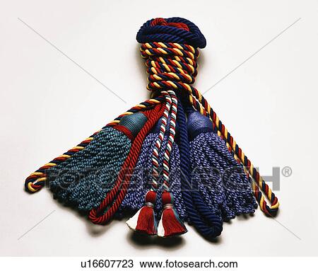 Stock Image - Close-up of blue and red silk tasselled tie-backs. Fotosearch