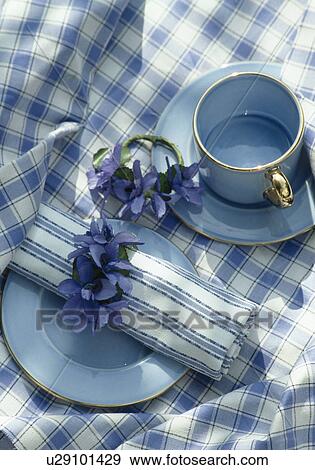 Stock Photo - Close-up of blue cup and blue checked table napkin on blue checked cloth. Fotosearch