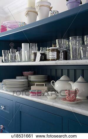Close-up of blue kitchen dresser with glasses and crockery on marble shelves View Large Photo Image Stock Image - Close-up of blue kitchen dresser with glasses and crockery on marble shelves. Fotosearch