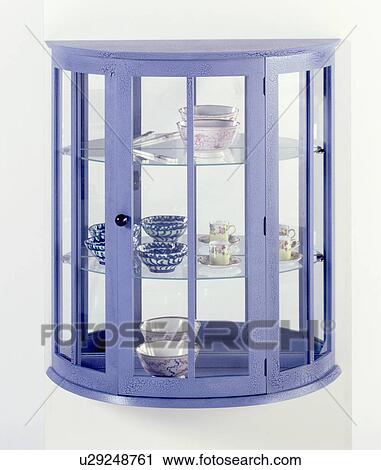 Stock Image - Close-up of blue thirties-style semi-circular glazed cupboard. Fotosearch